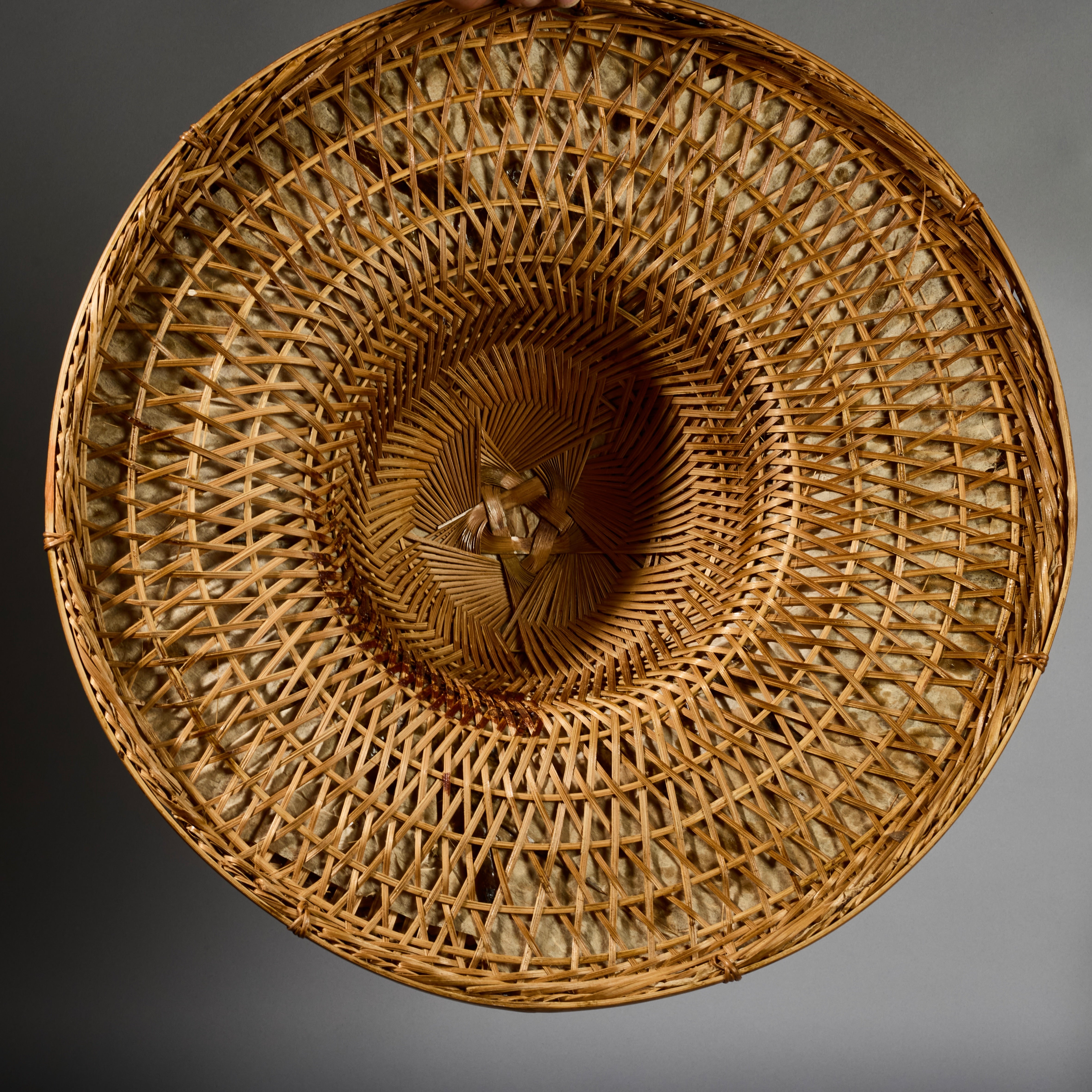 A VINTAGE LARGE WOVEN SUN HAT WITH DECORATIVE FLOURISH, FROM INDONESIA