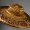 A VINTAGE LARGE WOVEN SUN HAT WITH DECORATIVE FLOURISH, FROM INDONESIA