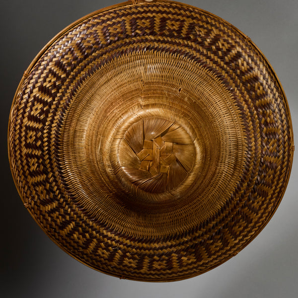 A VINTAGE LARGE WOVEN SUN HAT WITH DECORATIVE FLOURISH, FROM INDONESIA