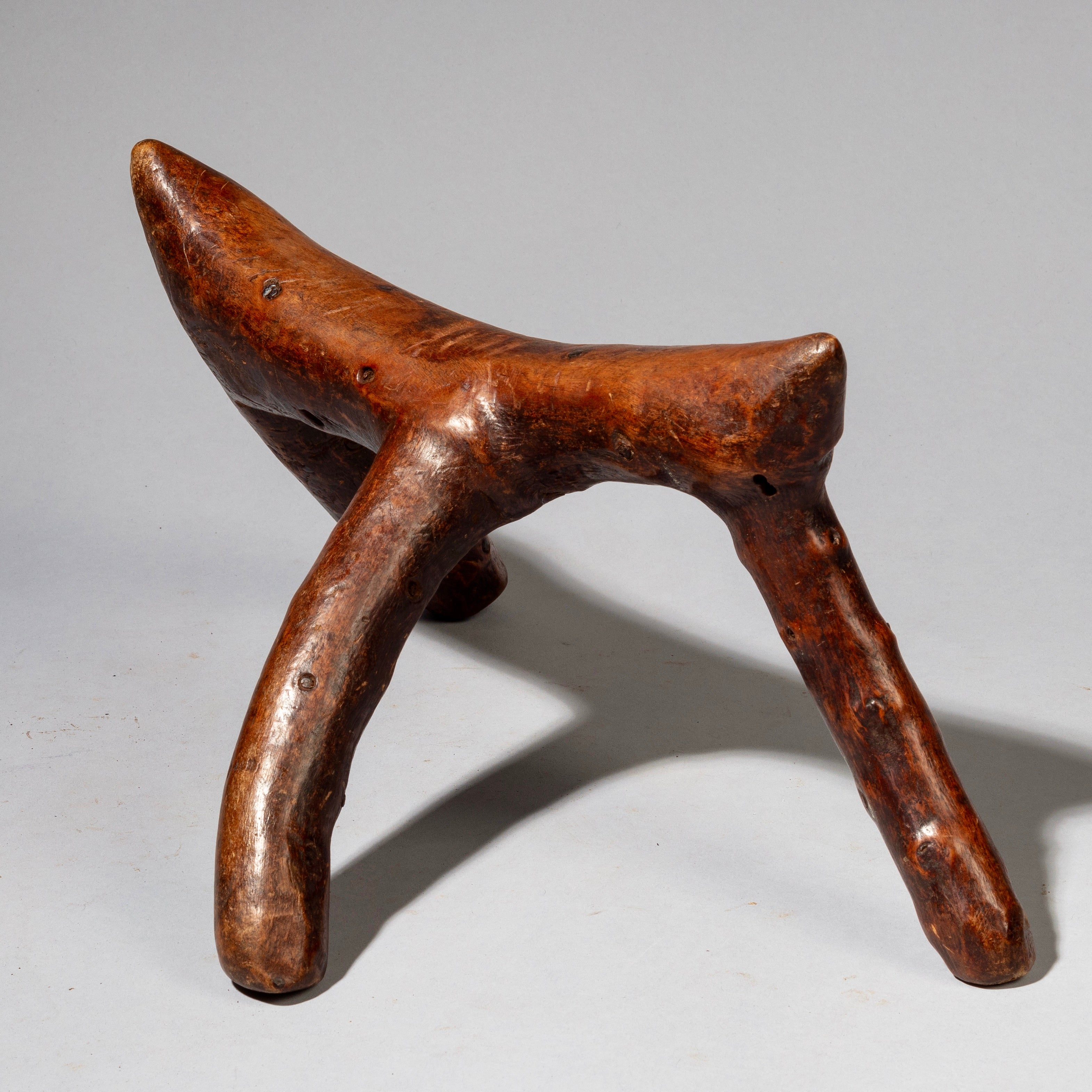 A WARMLY PATINATED 3 LEGGED HEADREST FROM KENYA ( No 2226)