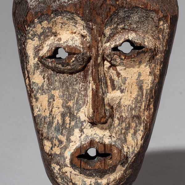 AN ASYMMETRIC PASSPORT MASK WITH REMNANTS OF PIGMENT , LEGA TRIBE OF CONGO ( No 2386)