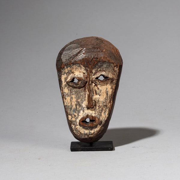 AN ASYMMETRIC PASSPORT MASK WITH REMNANTS OF PIGMENT , LEGA TRIBE OF CONGO ( No 2386)